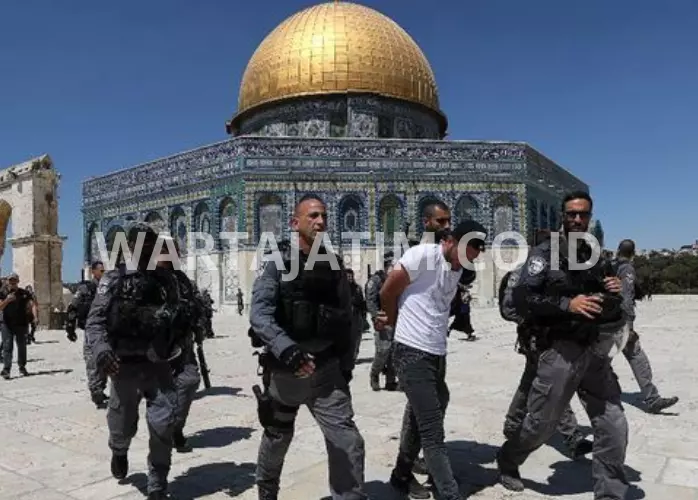 Ratusan pengungsi ISrael menyerbu MAsjid Al-Aqsa didampingi oleh pasukan militernya (cr. CNN Indonesia)