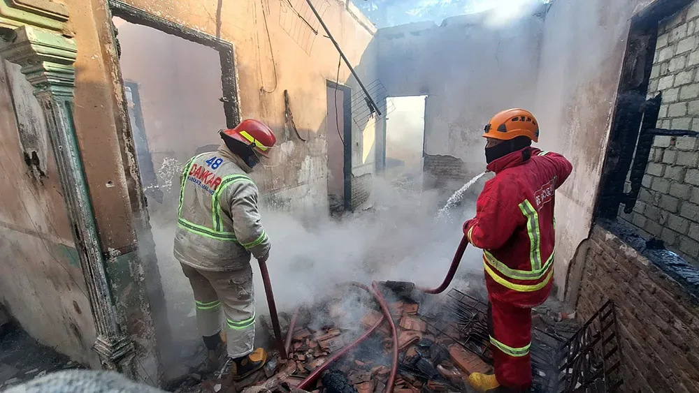 Personel Damkar Kabupaten Malang menyemprotkan air di rumah terbakar di Dusun Judeg, Desa Tlogorejo, Pagak, Senin (176) pagi.