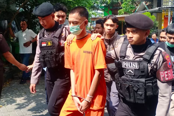 Hisyam Akbar Pahlevi alias Zombi (tengah) digelandang polisi untuk memperagakan aksi pembunuhan terhadap mahasiswi UM di Jalan Sumbersari, Lowokwaru, Malang